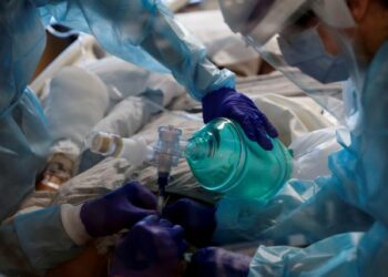 FILE PHOTO: Critical care workers insert an endotracheal tube into a coronavirus disease (COVID-19) positive patient in the intensive care unit (ICU) at Sarasota Memorial Hospital in Sarasota, Florida, February 11, 2021. REUTERS/Shannon Stapleton/File Photo