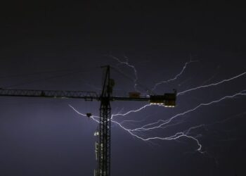 epa04390758 A picture made available on 08 September 2014 shows lightning behind a crane during a summer thunderstorm in San Sebastian, northern Spain, 07 September 2014.  EPA/JAVIER ETXEZARRETA