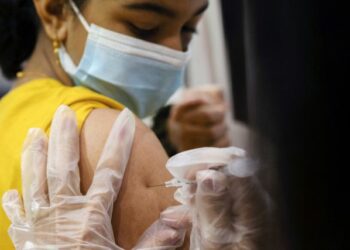 FILE PHOTO: A girl receives the Pfizer-BioNTech coronavirus disease (COVID-19) vaccine in Lansdale, Pennsylvania, U.S., December 5, 2021. REUTERS/Hannah Beier/File Photo