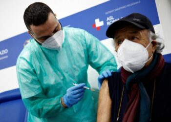 A person receives a dose of the Moderna vaccine against the coronavirus disease (COVID-19), on the day the government is expected to approve new rules for schools and COVID-19 vaccination for workers, at the Music Auditorium in Rome, Italy, January 5, 2022. REUTERS/Guglielmo Mangiapane