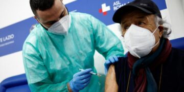 A person receives a dose of the Moderna vaccine against the coronavirus disease (COVID-19), on the day the government is expected to approve new rules for schools and COVID-19 vaccination for workers, at the Music Auditorium in Rome, Italy, January 5, 2022. REUTERS/Guglielmo Mangiapane