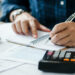 young man holding pen for fill out the document and take note to calculate business data, taxes, bills payment, Start up counting finance.accounting, statistics, and analytic research concept