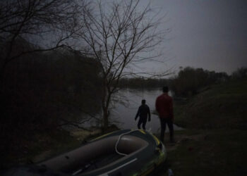 FILE - Migrants walk under moonlight next to an inflatable boat before attempting to enter Greece from Turkey by crossing the Evros river, also known as Maritsa river, near Edirne, Turkey, March 8, 2020. (AP Photo/Felipe Dana, File)