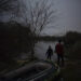 FILE - Migrants walk under moonlight next to an inflatable boat before attempting to enter Greece from Turkey by crossing the Evros river, also known as Maritsa river, near Edirne, Turkey, March 8, 2020. (AP Photo/Felipe Dana, File)