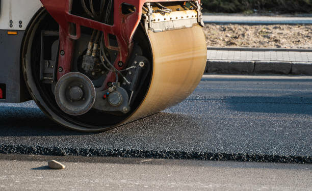 Asphalt road roller with heavy vibration roller compactor press new hot asphalt on the roadway on a road construction site. Heavy Vibration roller at asphalt pavement working. Repairing