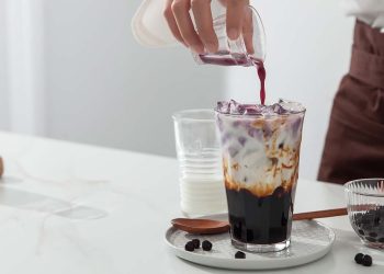 A man is making brown sugar vanilla pearl milk tea